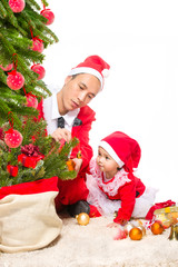 Happy family in Christmas eve at home sitting near decorated fir