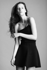 Fototapeta premium beautiful young model in elegant black dress posing in the studi
