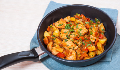 meat stew with potatoes, pepper, onion and carrot in a frying pan