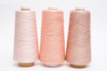 Fototapeta na wymiar Spools of thread peach color on a white background