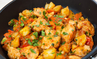 meat stew with potatoes, pepper, onion and carrot in a frying pan