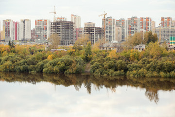 Fototapeta na wymiar Residential apartments on a river bank in autumn