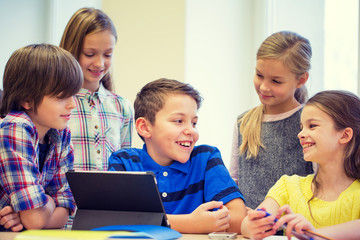 group of school kids with tablet pc in classroom