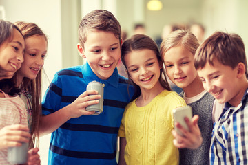 group of school kids with smartphone and soda cans