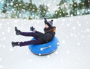 happy young man sliding down on snow tube