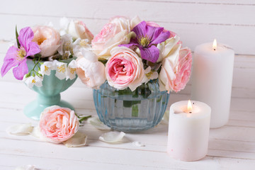 Pink roses, white jasmine and violet clematis flowers and candle