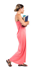 Naklejka premium A girl carries a heavy pile of books. side view.