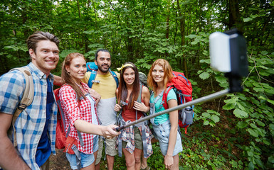 friends with backpack taking selfie by smartphone