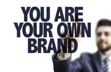 Business man pointing the text: You Are Your Own Brand