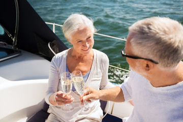 senior couple clinking glasses on boat or yacht