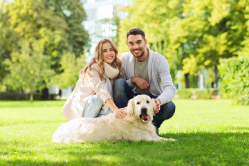 happy couple with labrador dog walking in city