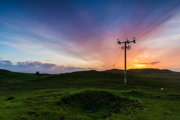 Fototapeta na wymiar Telephone or electricity line in the fields at sunset