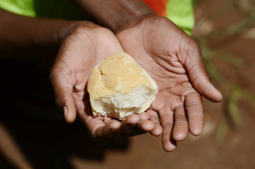 African Black Girl Holding Bread Malnutrition Hunger Stunted Symbol. Black African girl holding...