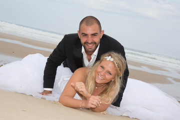 An attractive bride and groom getting married by the beach