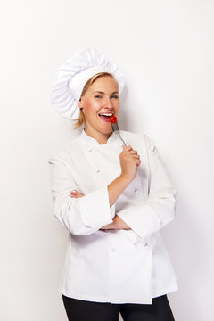 Woman chef showing a sign perfect, with tomato on fork, over whi