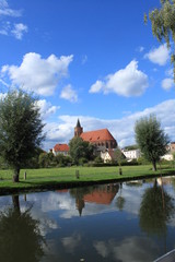 Obraz premium Idyllisches Kleinstadtpanorama: Blick über die Spree auf den historischen Stadtkern von Beeskow mit Marienkirche