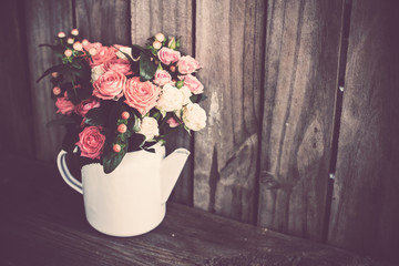 Bouquet of roses in vintage coffee pot