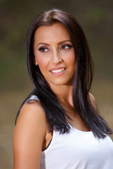 Fototapeta premium Smiling young woman enjoying her time outside in park