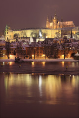 Fototapeta premium Night romantic colorful snowy Prague gothic Castle with Charles Bridge, Czech Republic