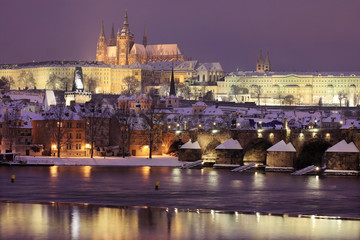 Fototapeta na wymiar Night romantic colorful snowy Prague gothic Castle with Charles Bridge, Czech Republic
