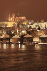 Fototapeta premium Night romantic colorful snowy Prague gothic Castle with Charles Bridge, Czech Republic