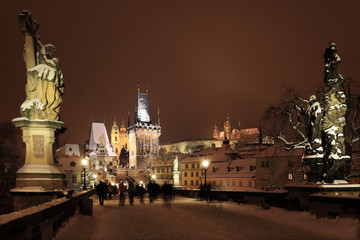 Night snowy Prague gothic Castle, Bridge Tower and St. Nicholas' Cathedral, Czech republic