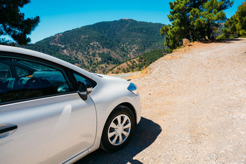 White color small hatchback car on Spainish nature mountains lan