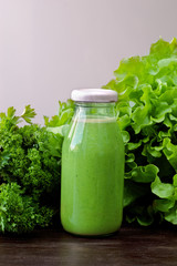 Green smoothie with parsley on wooden table
