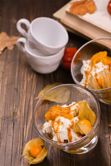 Delicious layered pumpkin dessert with cream, cookies, fruits and spices. Vintage style. Selective focus