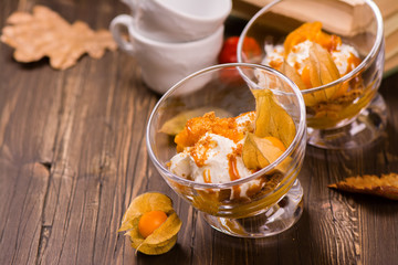 Delicious layered pumpkin dessert with cream, cookies, fruits and spices. Vintage style. Selective focus