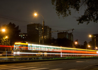 Fototapeta na wymiar tram on transport stop and crosswalk at night