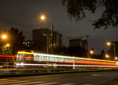 tram on transport stop and crosswalk at night