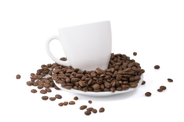 White cup on a white plate with full of roasted coffee beans.