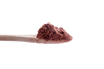 cocoa powder on spoon over white background