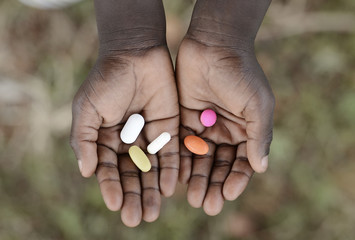 Curing Malaria - African Girl Holding Pills Medicine Health Symbol. Medicine and healthcare pills are very important in the black continent.