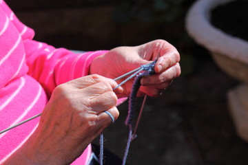 Woman knitting outdoor.
Senior lady outdoor in sunshine knitting.