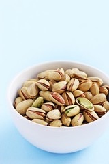 Pistachios nuts on a light blue background.Selective focus.