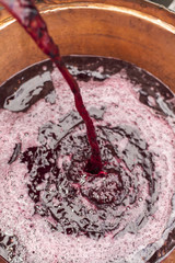 Preparazione del vino cotto: specialità italiana. Mosto d'uva riversato nella pentola in rame per la bollitura