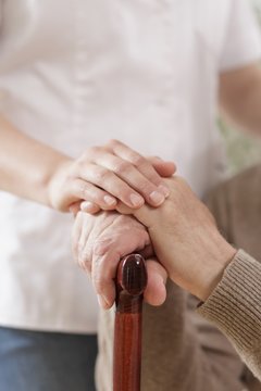 Kind caregiver holding senior man