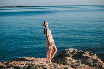 beautiful girl standing on rocky outcrops seaside