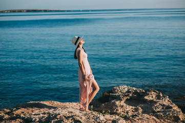 beautiful girl standing on rocky outcrops seaside