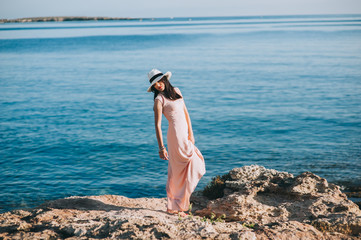 beautiful girl standing on rocky outcrops seaside