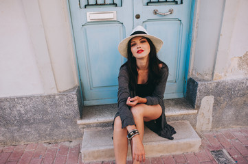 young beautiful girl with  hat posing against the backdrop of a