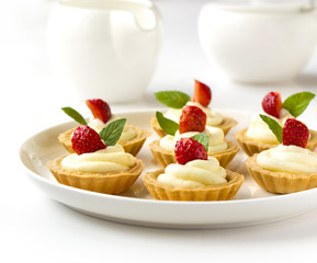 Many cakes, cupcakes with fresh fruits, whipped cream, jelly and mints