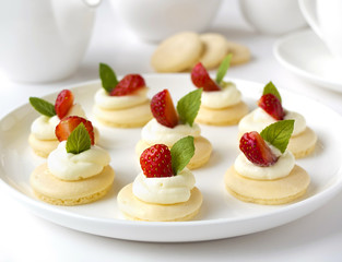 Many cakes, cupcakes with fresh fruits, whipped cream, jelly and mints