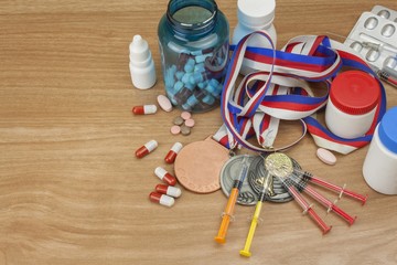 Doping in sport. Abuse of anabolic steroids for sports. Anabolic steroids spilled on a wooden...