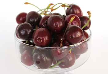 Cherries in a vase on a white background.