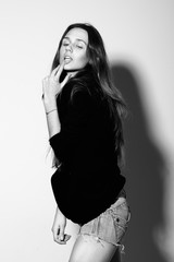 Attractive young woman posing by the wall.