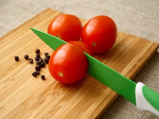 tomatoes with black pepper on the board with knife