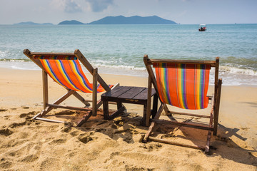 sun beach chairs on shore near sea.
